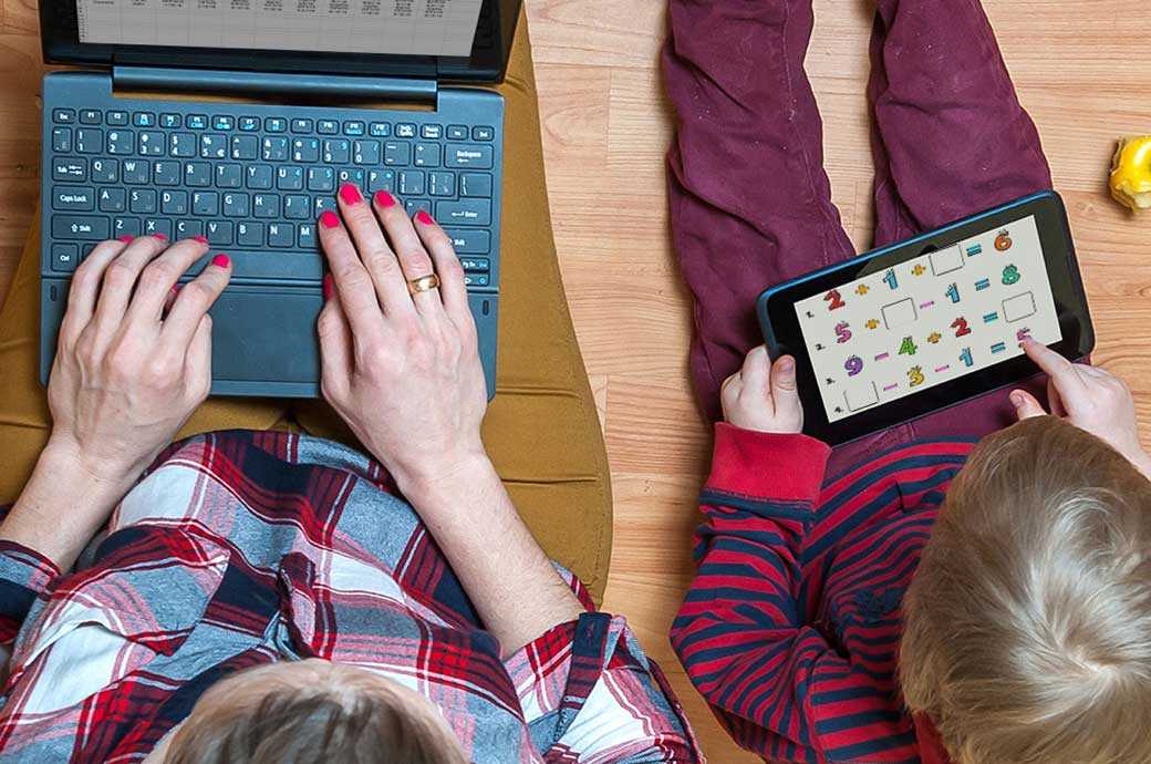 Parent and child using a laptop and a tablet